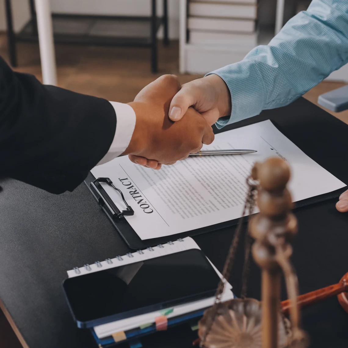 Business agreement handshake with contract